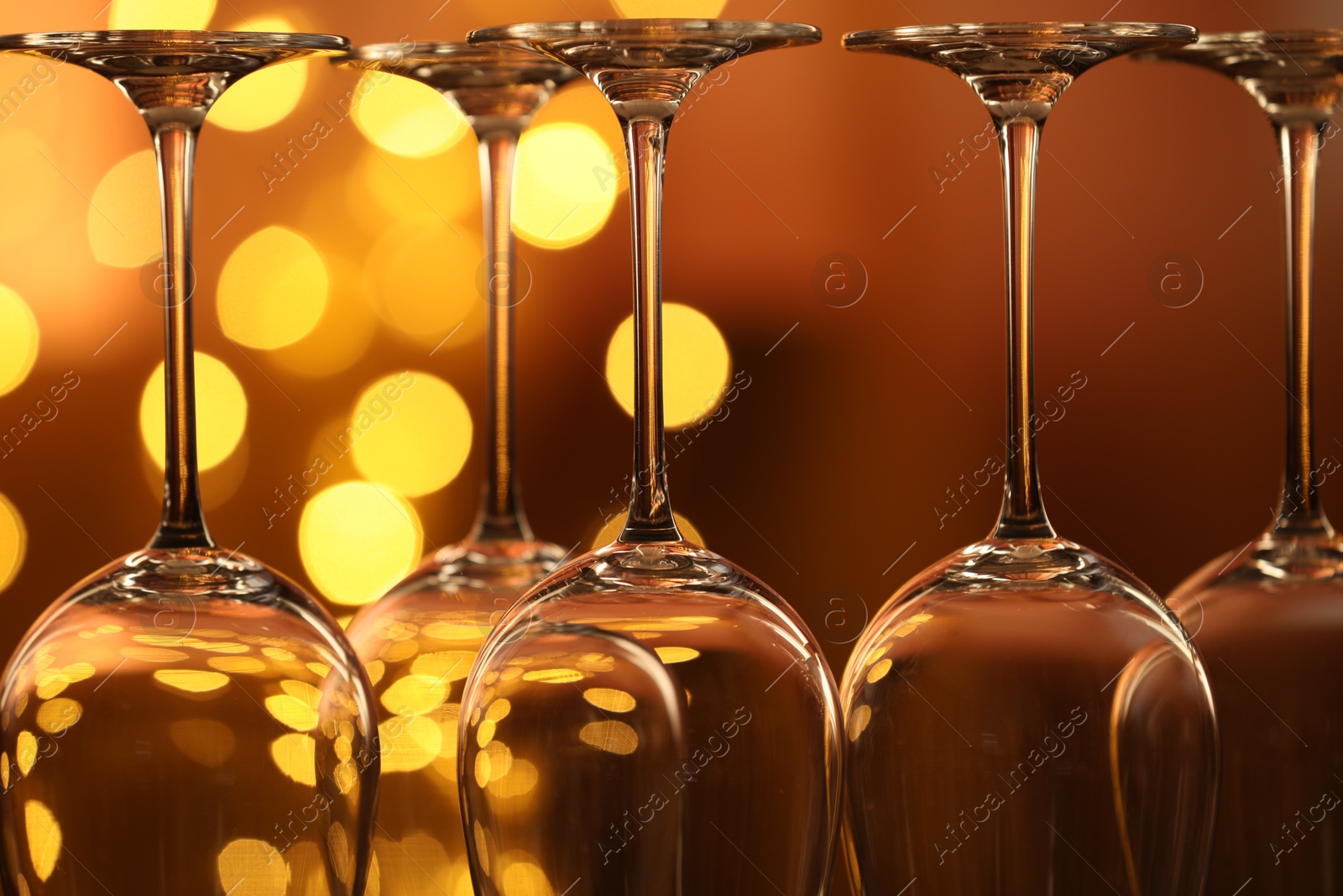 Many clean glasses against blurred lights, closeup. Bokeh effect Photo of Many clean glasses against blurred lights, closeup. Bokeh effect