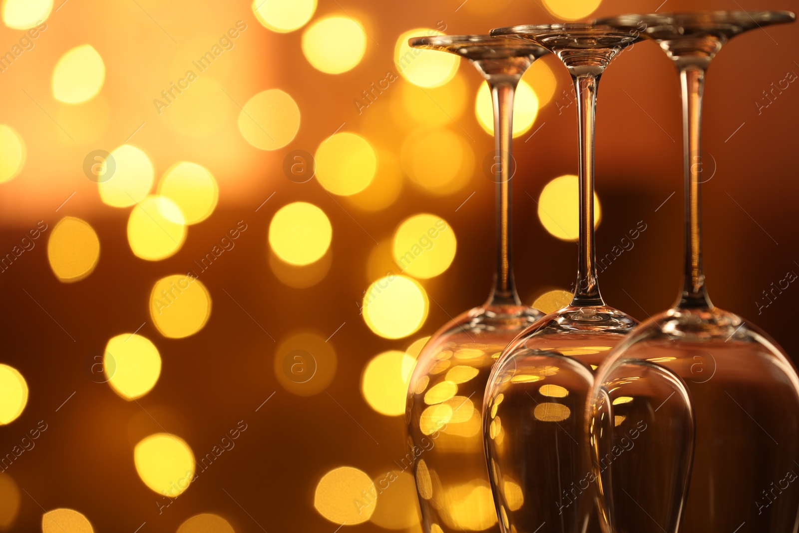 Many clean glasses against blurred lights, closeup. Bokeh effect Photo of Many clean glasses against blurred lights, closeup. Bokeh effect