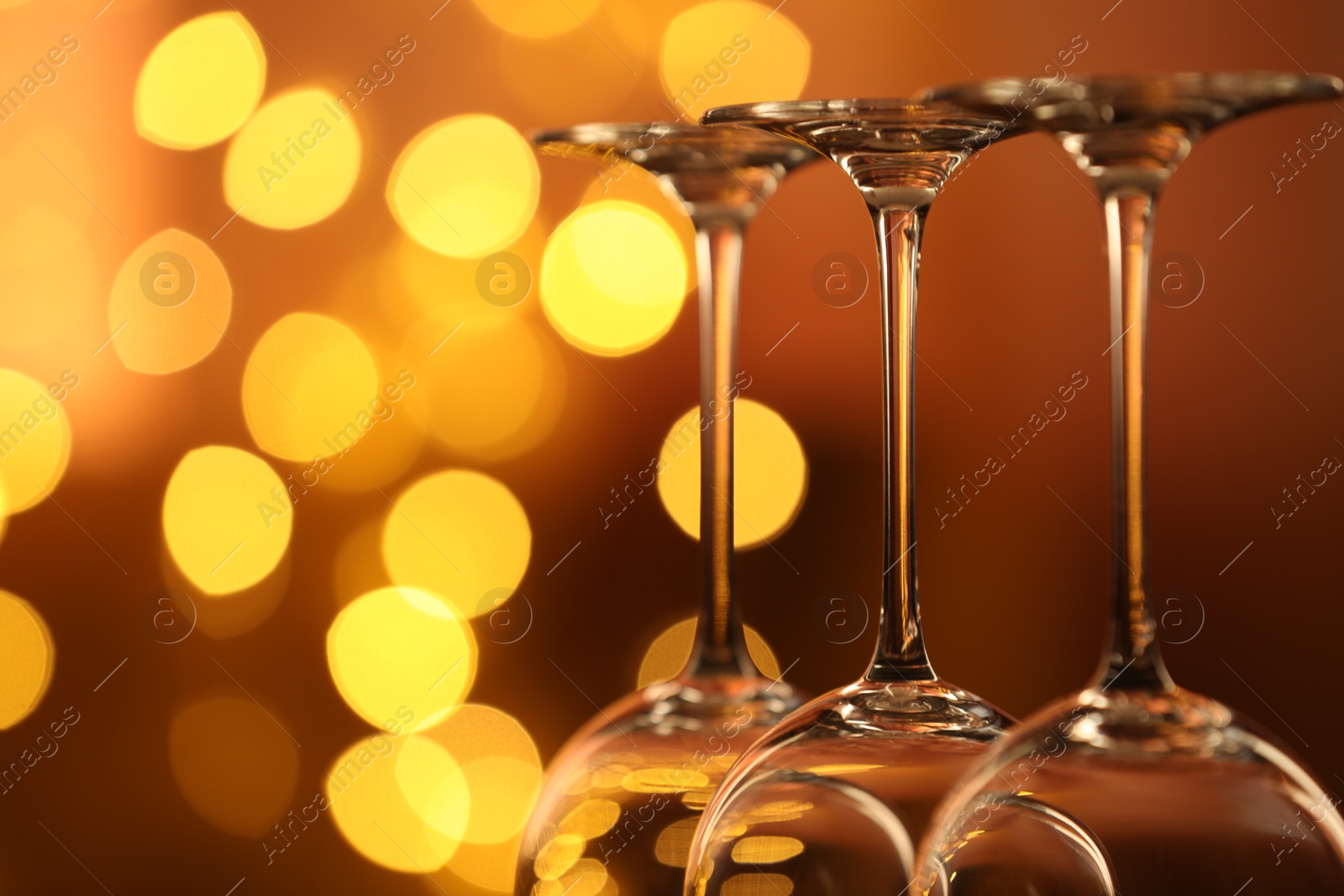 Many clean glasses against blurred lights, closeup. Bokeh effect Photo of Many clean glasses against blurred lights, closeup. Bokeh effect