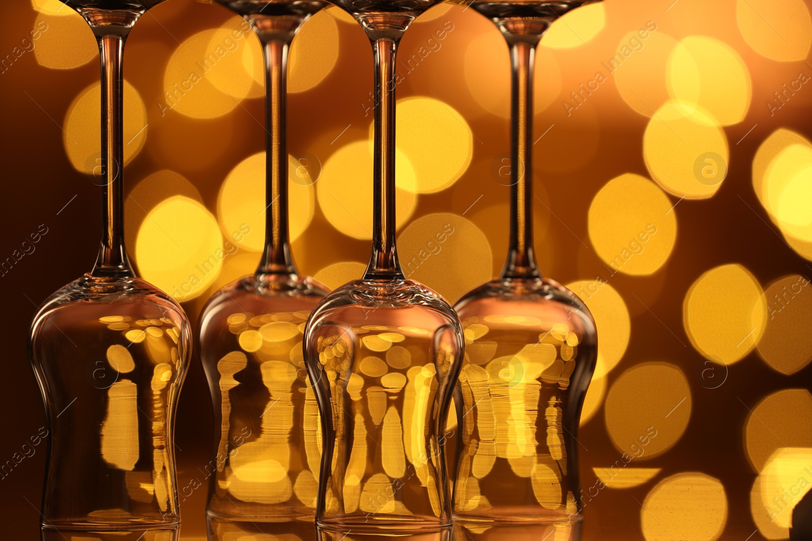 Many clean glasses on glass mirror surface against blurred lights. Bokeh effect Photo of Many clean glasses on glass mirror surface against blurred lights. Bokeh effect