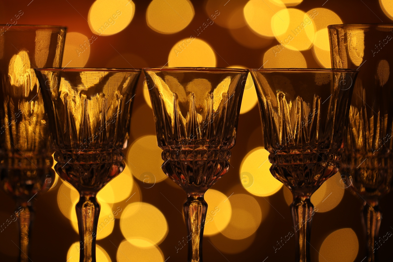 Many clean glasses against blurred lights, closeup. Bokeh effect Photo of Many clean glasses against blurred lights, closeup. Bokeh effect