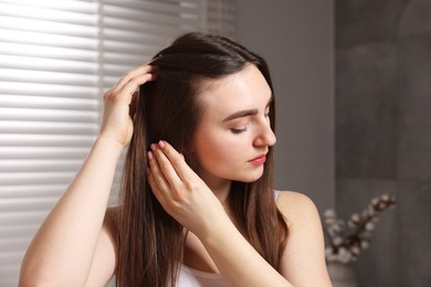 Photo of Beautiful woman with healthy hair roots at home