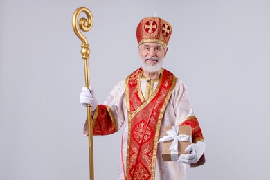 Photo of Saint Nicholas with gift on light grey background