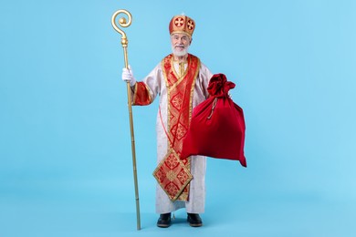 Photo of Saint Nicholas with sack on light blue background