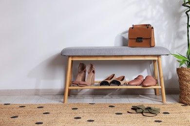 Photo of Stand with different stylish shoes, bag and houseplant indoors. Space for text