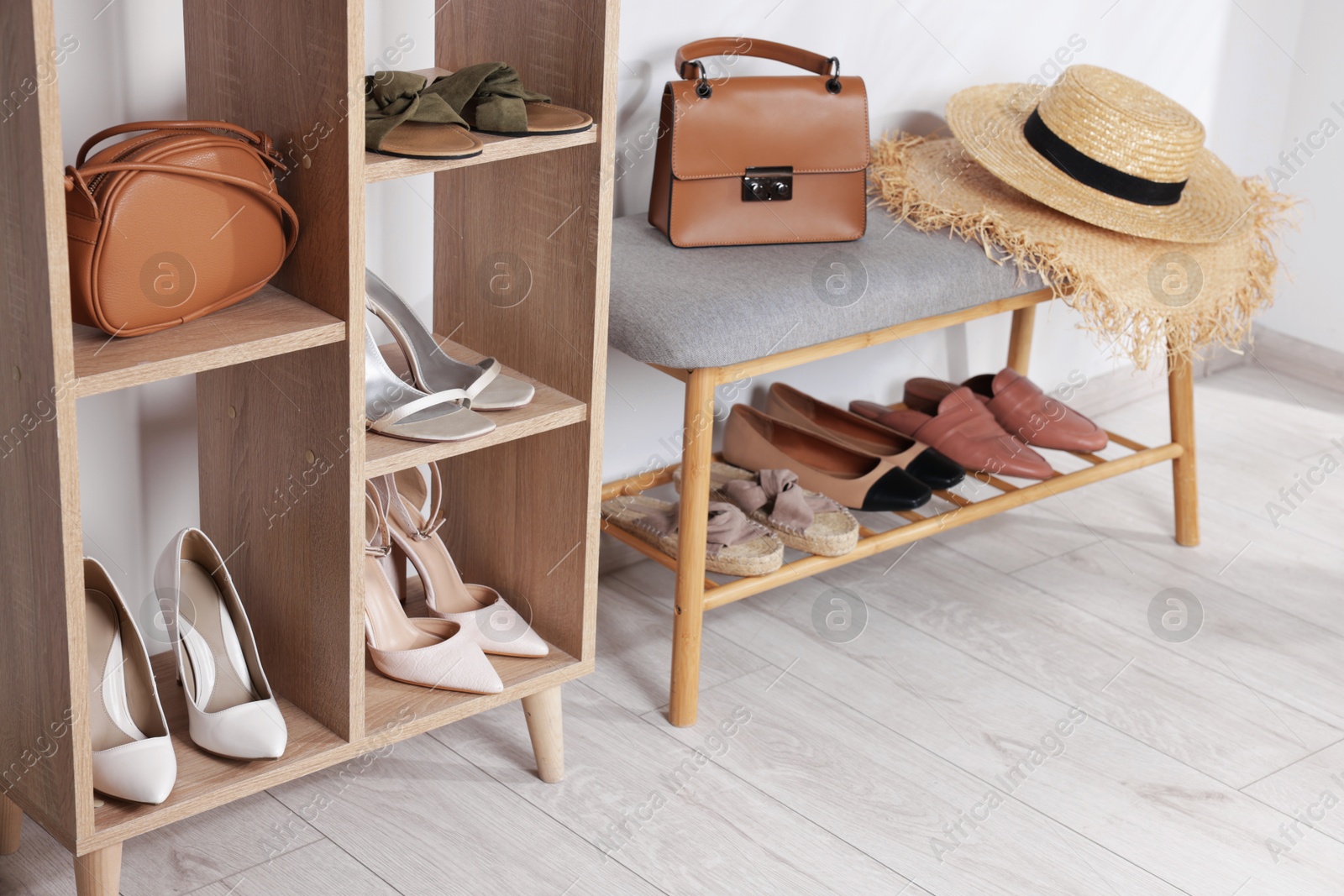 Stands with different stylish shoes, straw hats and bags indoors Photo of Stands with different stylish shoes, straw hats and bags indoors