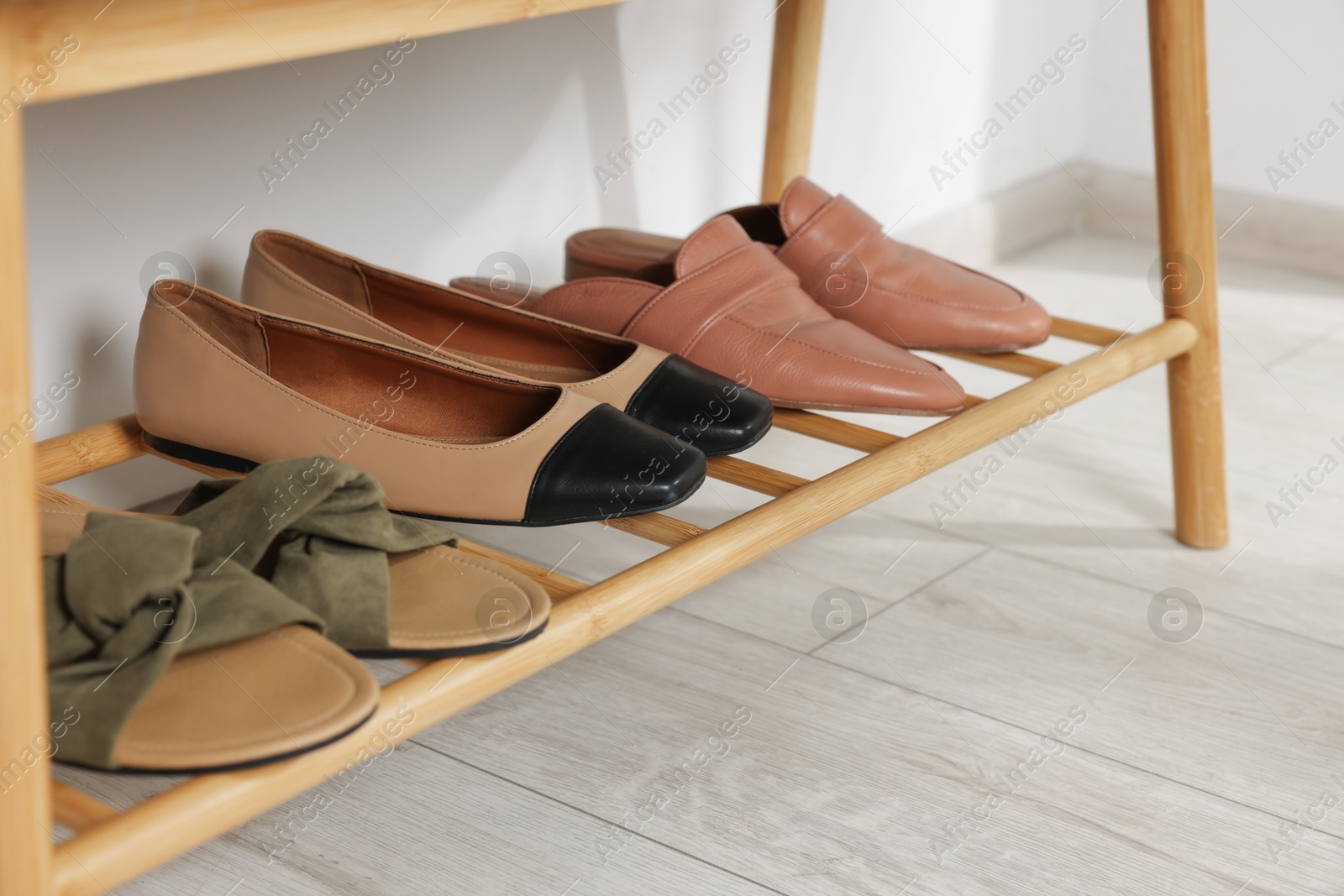 Stand with different stylish shoes indoors, closeup Photo of Stand with different stylish shoes indoors, closeup