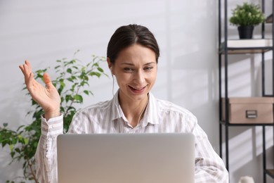 Photo of Smiling online speaker streaming webinar with laptop indoors