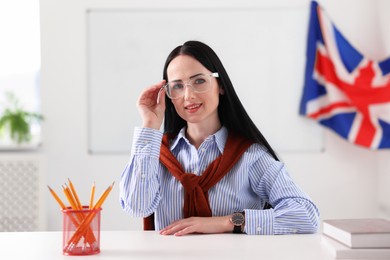 Photo of English teacher working at desk in classroom