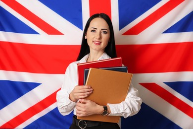 Photo of English teacher with books against UK flag