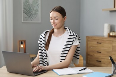 Photo of Woman learning online using laptop at table indoors. Self-study