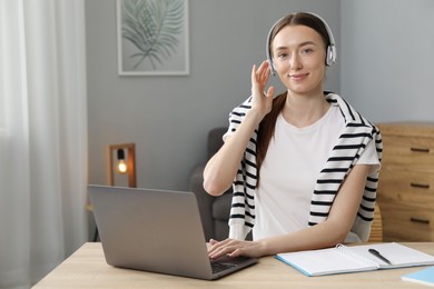 Photo of Woman learning online using laptop at table indoors. Self-study