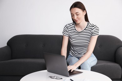 Photo of Woman learning online using laptop at table indoors. Self-study