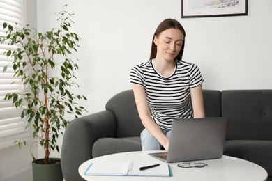 Photo of Woman learning online using laptop at table indoors. Self-study