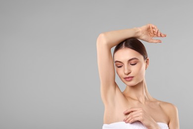 Photo of Young woman showing smooth skin after epilation on gray background, space for text