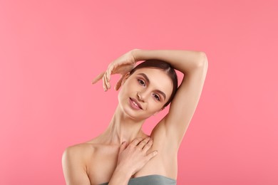 Photo of Young woman showing smooth skin after epilation on pink background