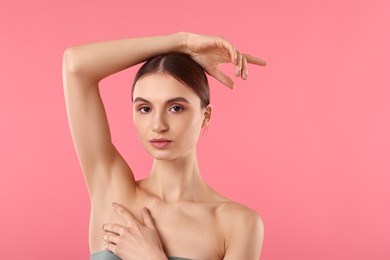 Photo of Young woman showing smooth skin after epilation on pink background, space for text