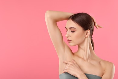 Photo of Young woman showing smooth skin after epilation on pink background, space for text