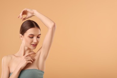 Photo of Young woman showing smooth skin after epilation on beige background, space for text