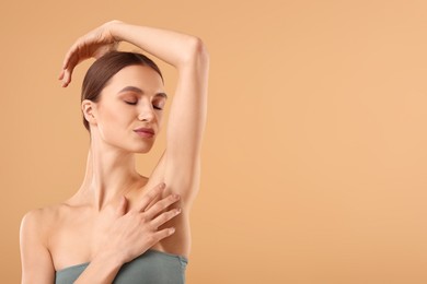 Photo of Young woman showing smooth skin after epilation on beige background, space for text