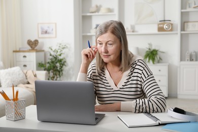 Photo of Woman learning online using laptop at table indoors. Self-study