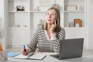 Photo of Woman learning online using laptop at table indoors. Self-study