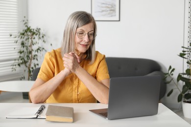 Photo of Woman learning online using laptop at table indoors. Self-study