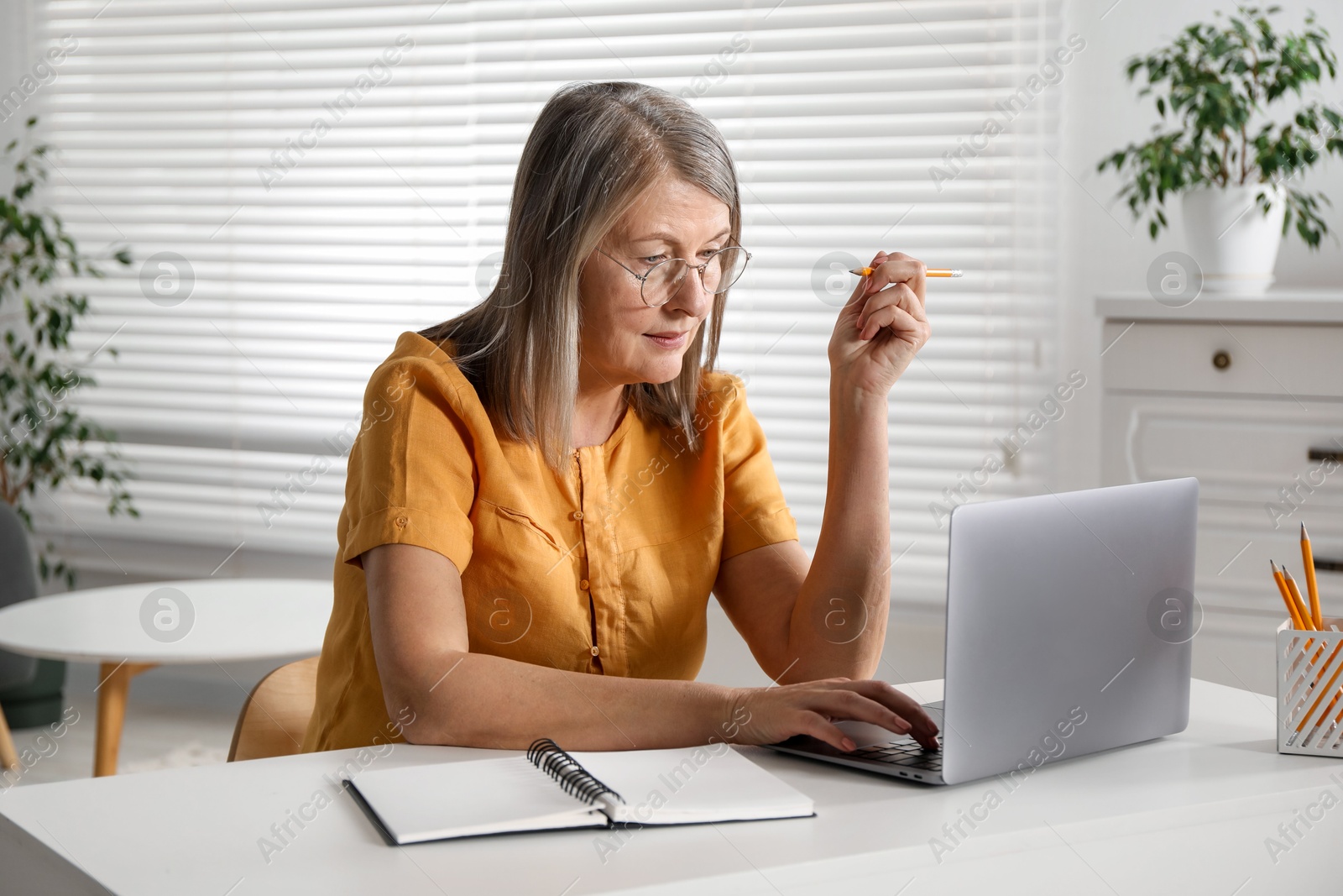 Photo of Woman learning online using laptop at table indoors. Self-study