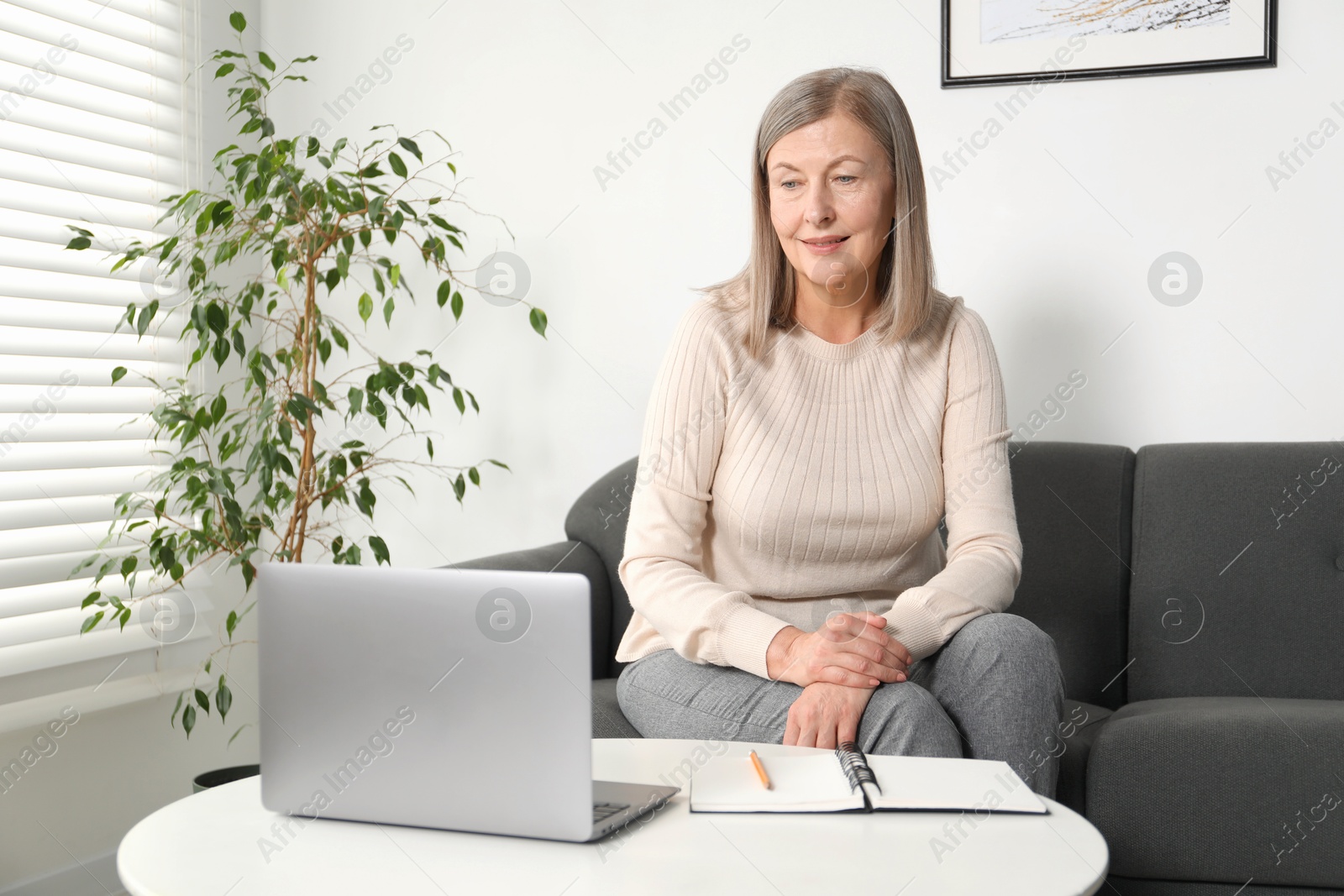 Photo of Woman learning online using laptop at table indoors. Self-study