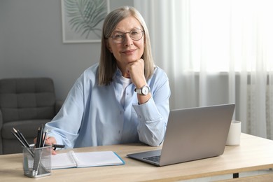 Photo of Woman learning online using laptop at table indoors. Self-study