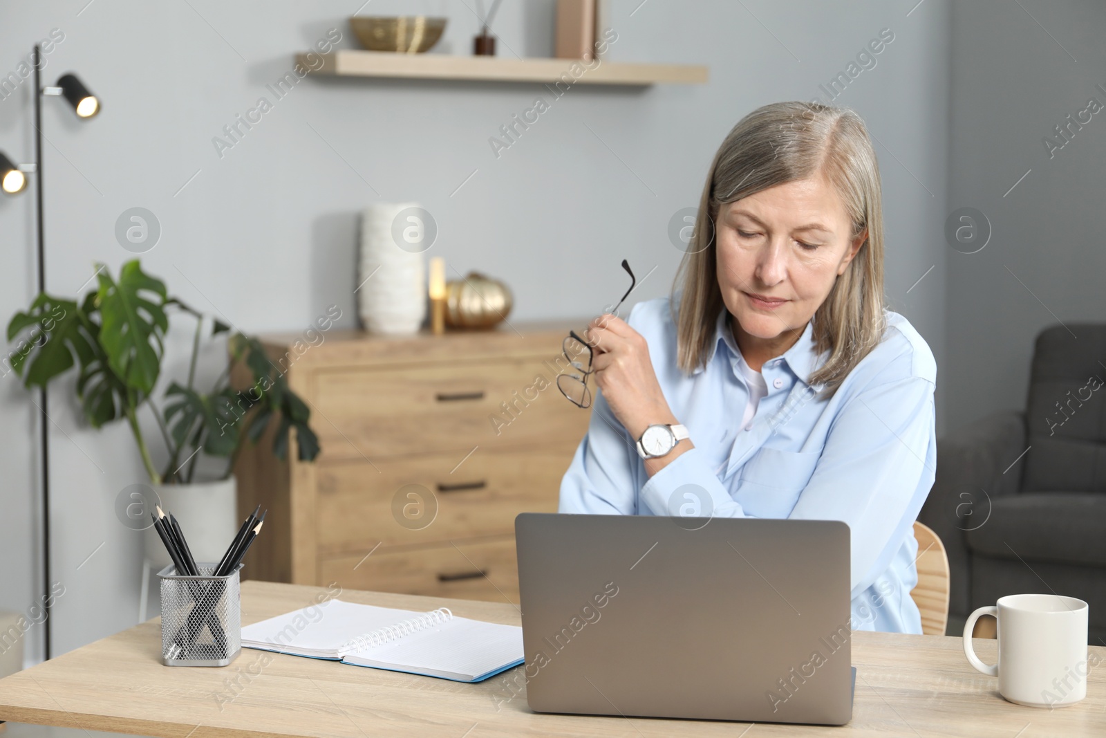 Photo of Woman learning online using laptop at table indoors. Self-study