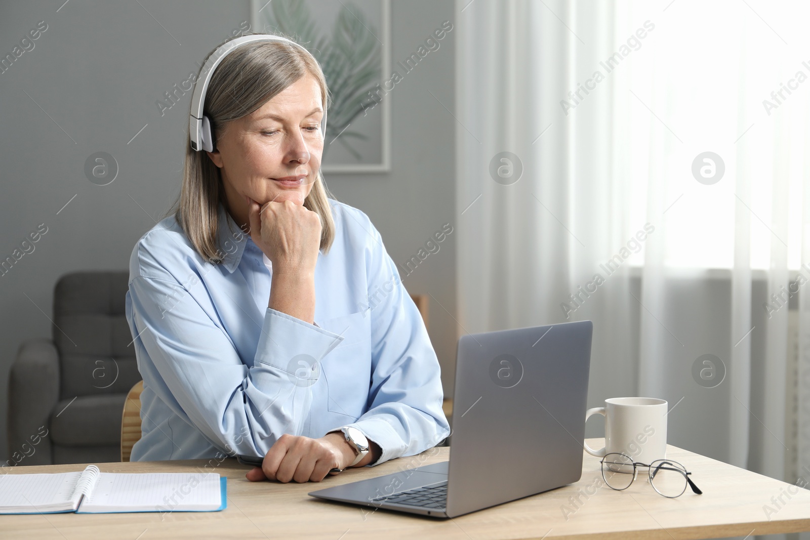 Photo of Woman learning online using laptop at table indoors. Self-study