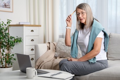 Photo of Woman learning online using laptop at table indoors. Self-study