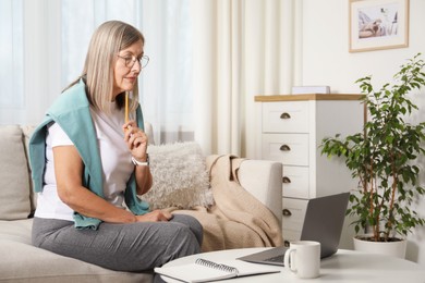 Photo of Woman learning online using laptop at table indoors. Self-study