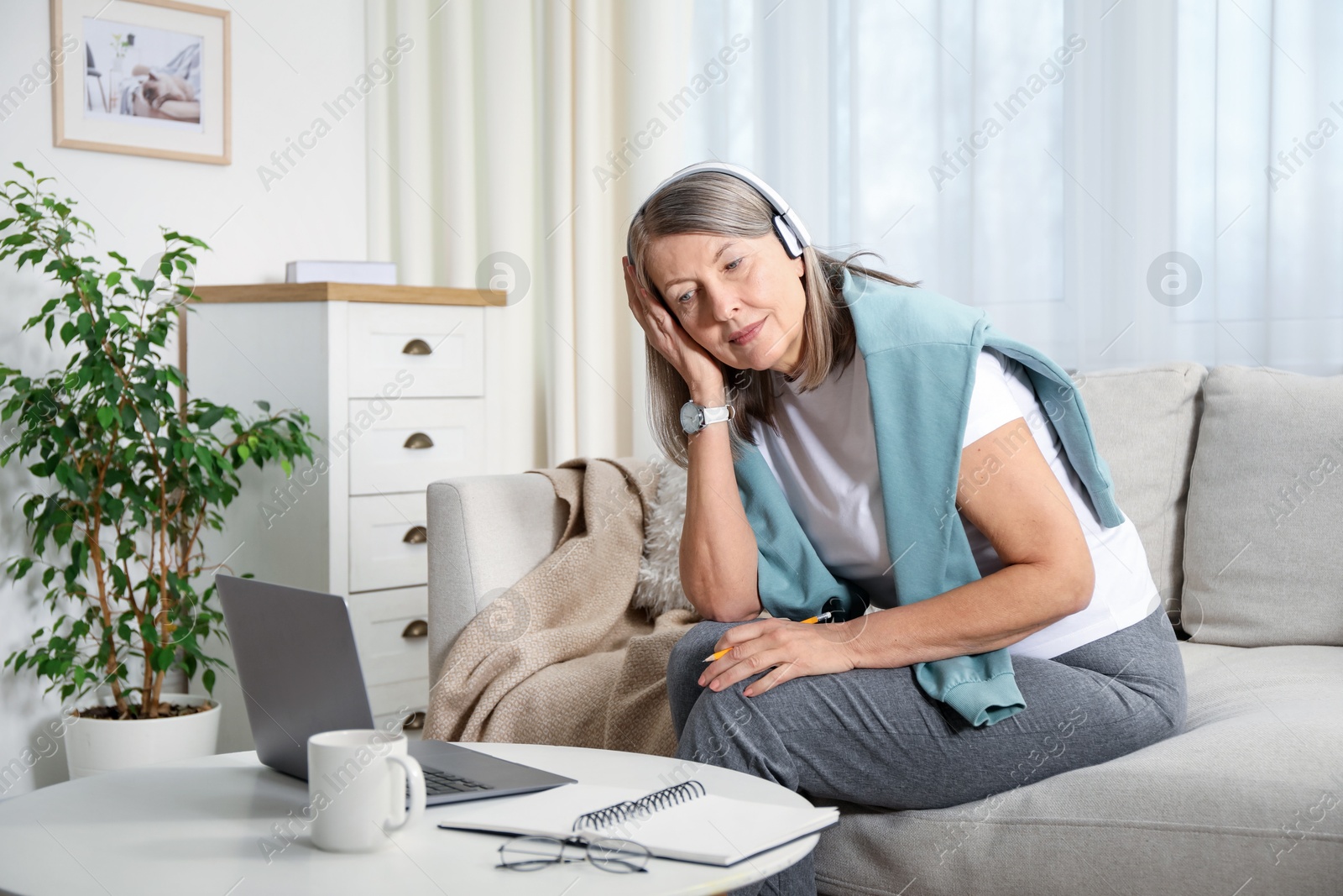 Photo of Woman learning online using laptop at table indoors. Self-study