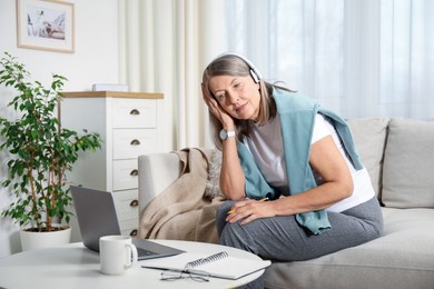 Photo of Woman learning online using laptop at table indoors. Self-study