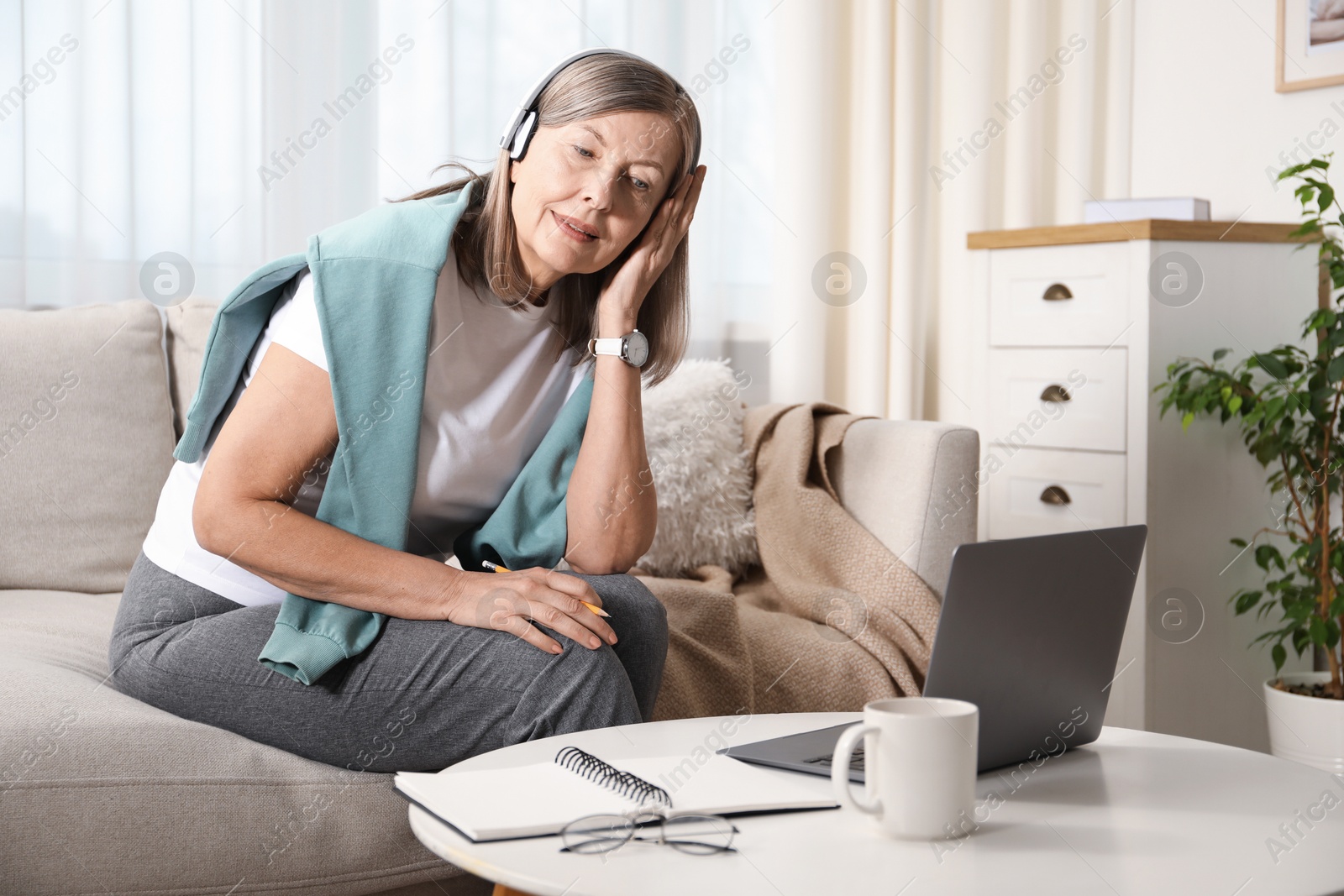 Photo of Woman learning online using laptop at table indoors. Self-study