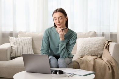 Photo of Woman learning online using laptop at table indoors. Self-study