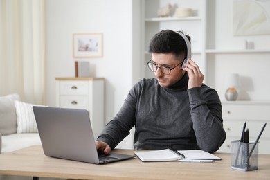 Photo of Man learning online using laptop at desk indoors. Self-study