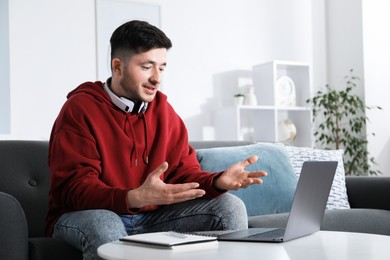 Photo of Man having online lesson with teacher via laptop at table indoors