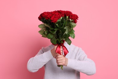 Photo of Senior man with bouquet of red roses on pink background