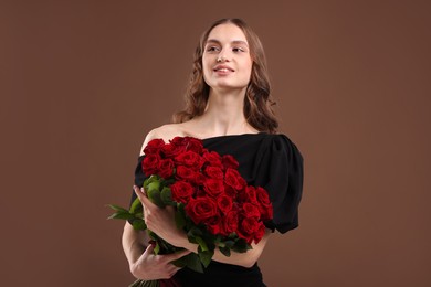 Photo of Smiling woman with bouquet of roses on brown background