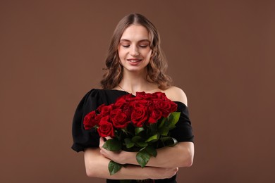 Photo of Smiling woman with bouquet of roses on brown background