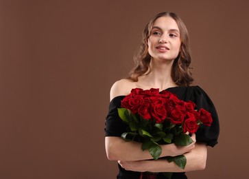 Photo of Smiling woman with bouquet of roses on brown background. Space for text