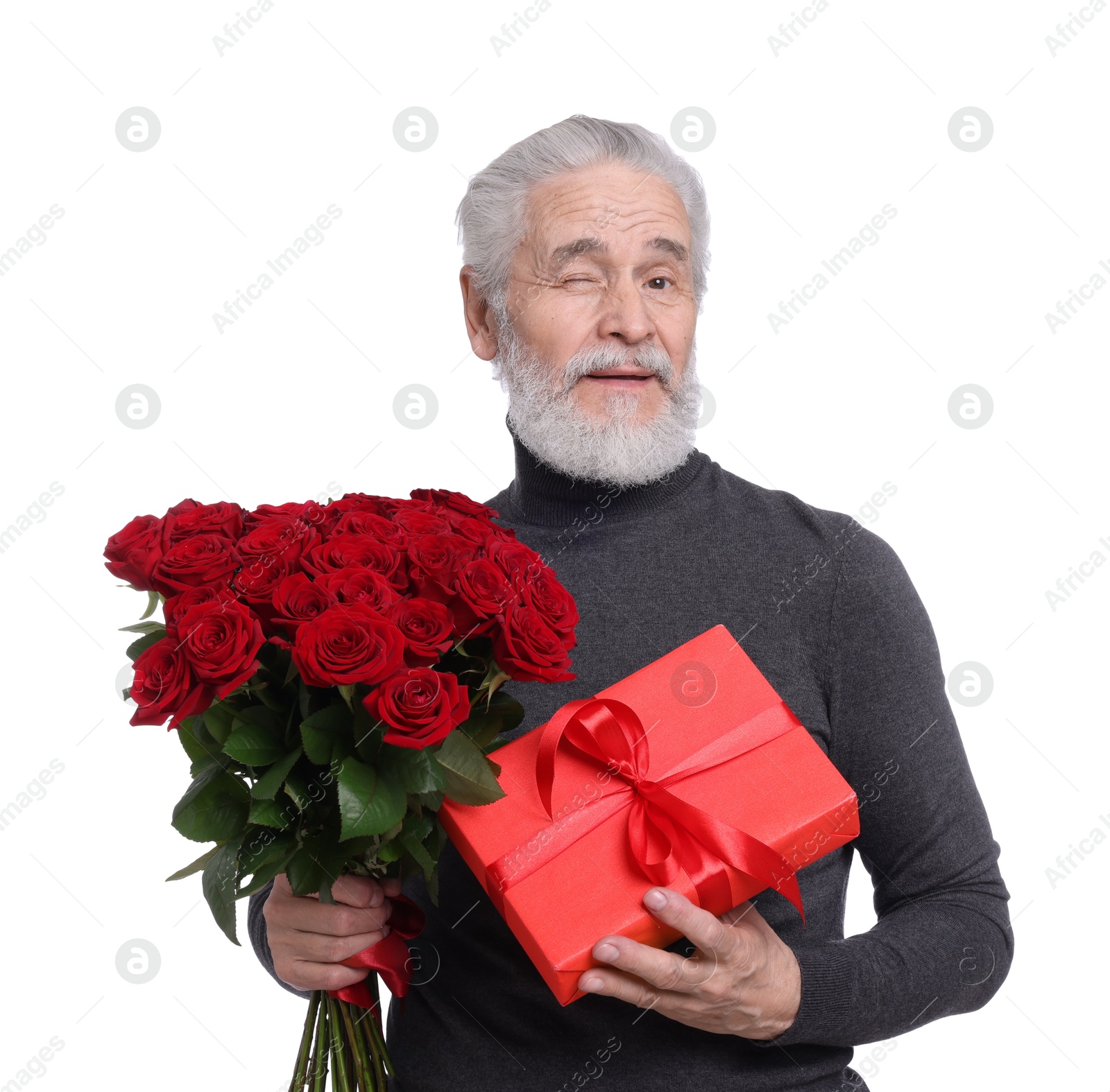 Photo of Senior man with bouquet of red roses and gift box on white background