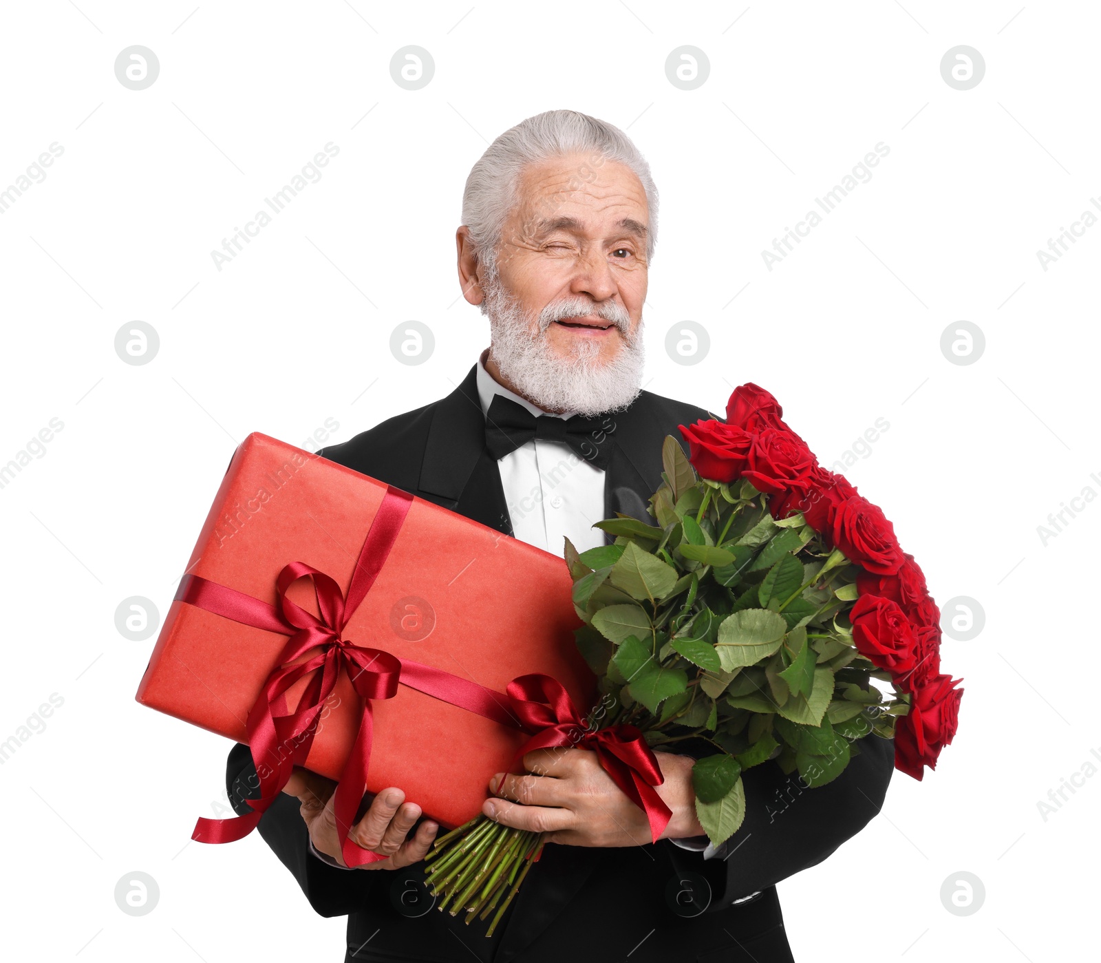 Photo of Senior man with bouquet of red roses and gift box on white background