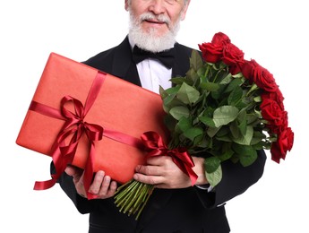 Photo of Senior man with bouquet of red roses and gift box on white background, closeup