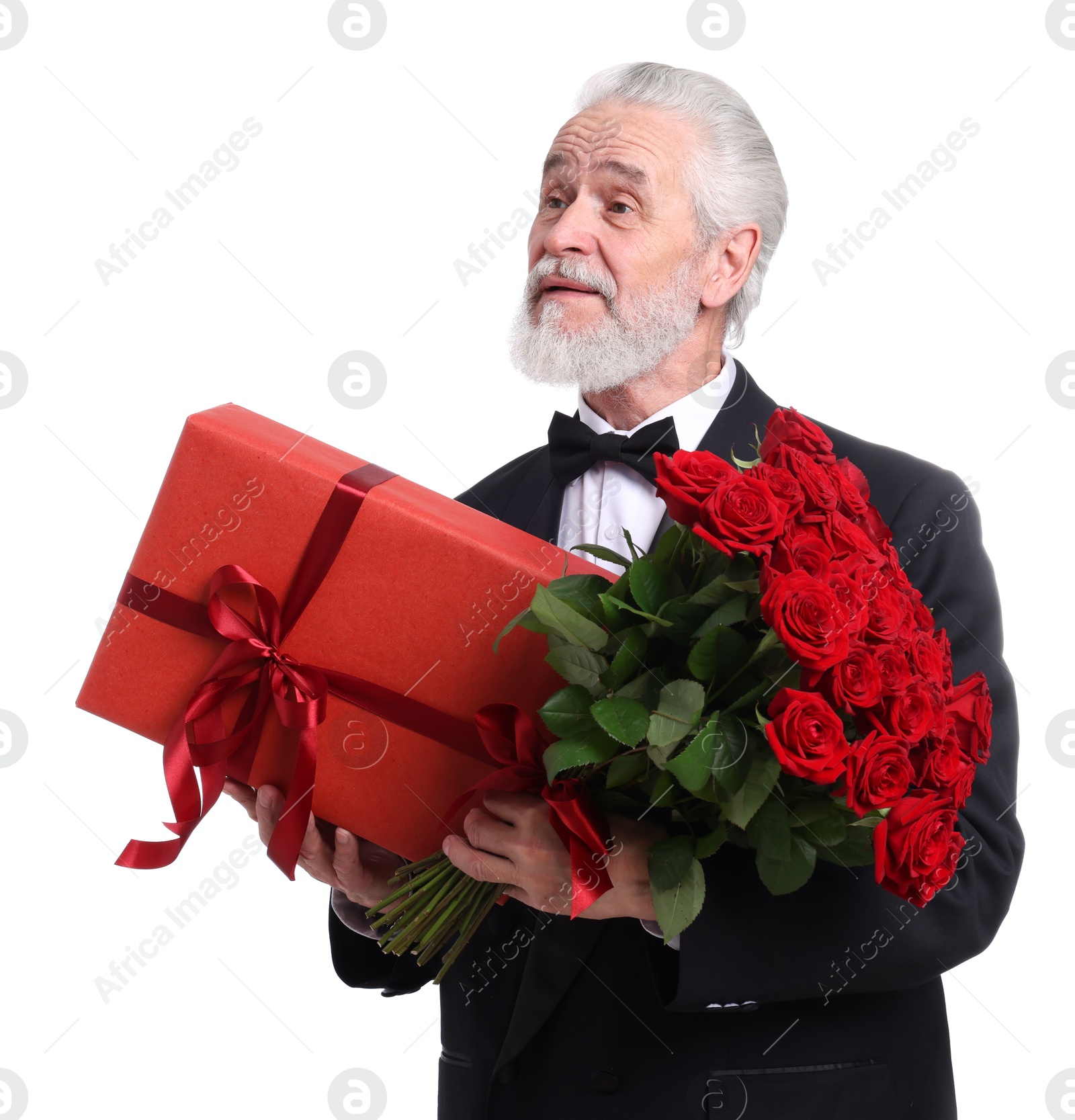 Photo of Senior man with bouquet of red roses and gift box on white background