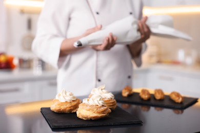 Photo of Professional pastry chef making desserts at table in kitchen, closeup