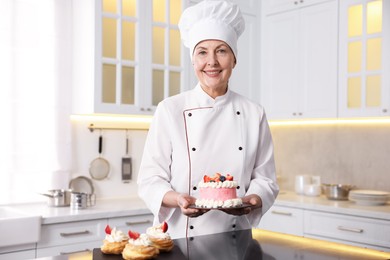 Photo of Professional pastry chef with cake in kitchen